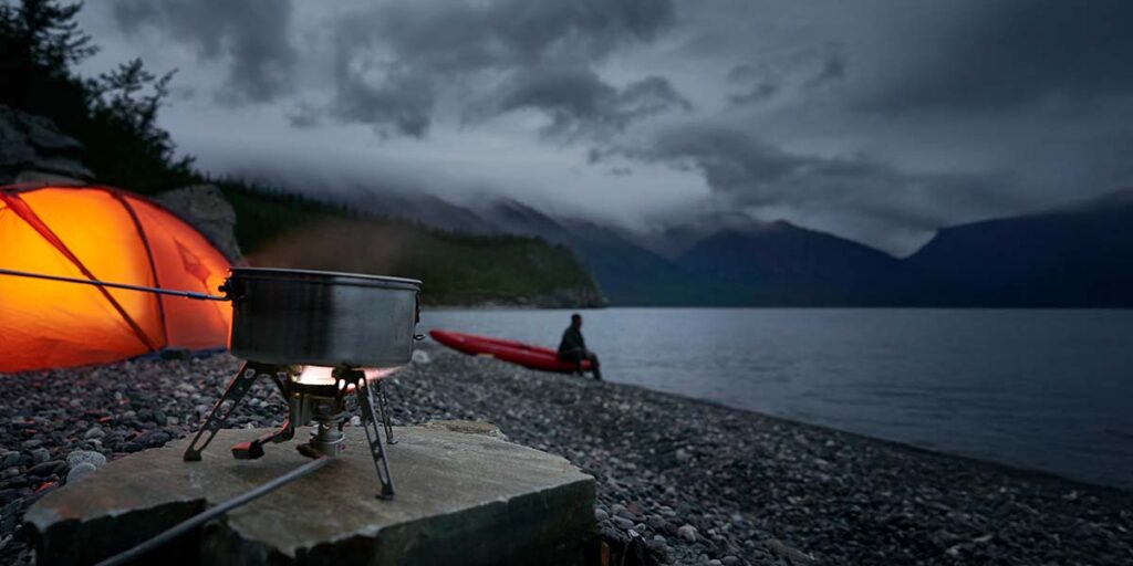 Kayak camping camp stove beside the lake